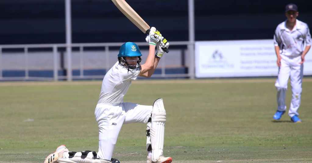 Two young cricketers playing a match, showcasing batting skills on the field.