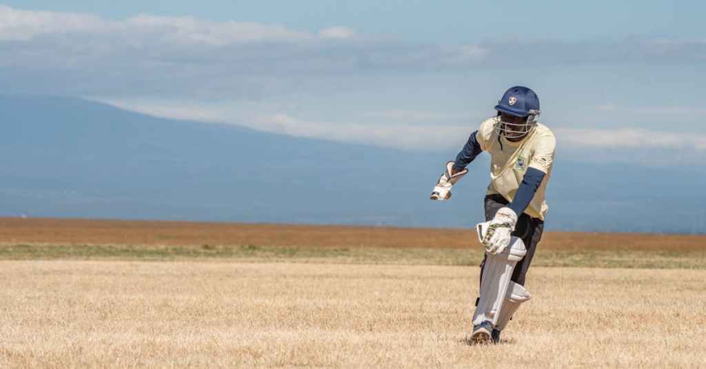 A cricket player batting outdoors on a sunny day, showcasing athletic skill.